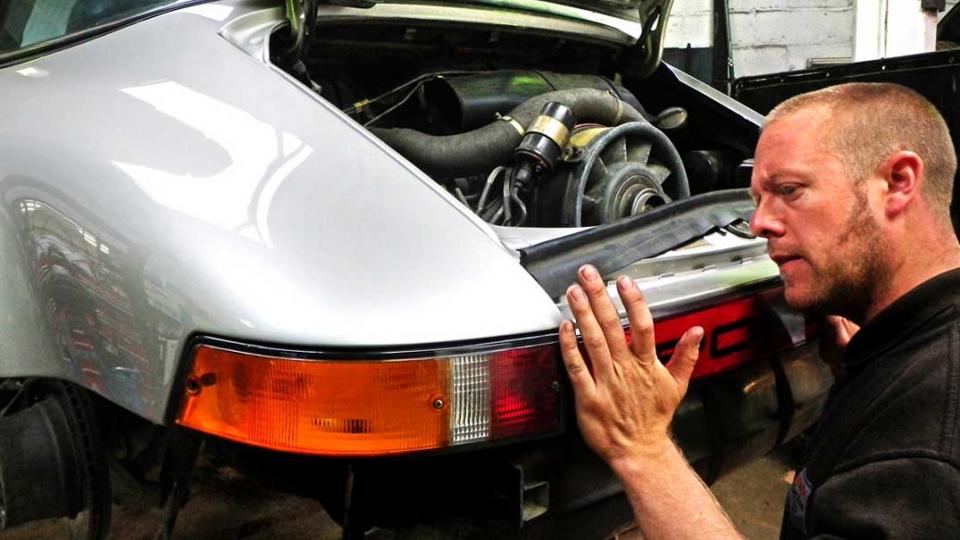 Dave refits the rear trim to a Porsche 911 after body work repair