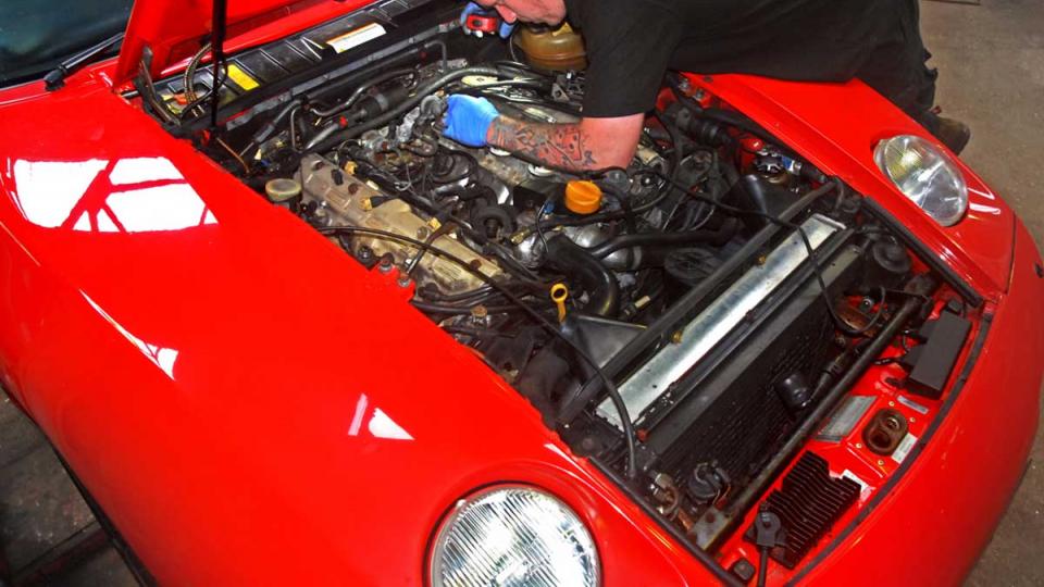 Matt inspects for leaking hoses on the Porsche 928