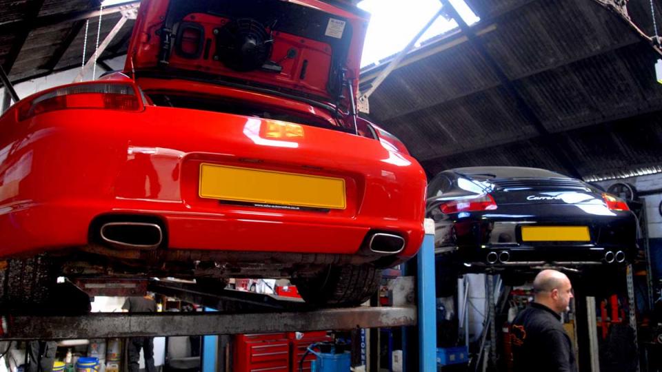 A pair of Porsche 996's on ramps ready for servicing to start