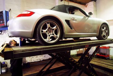 Inspecting the underside components and chassis of a Porsche Boxster 987